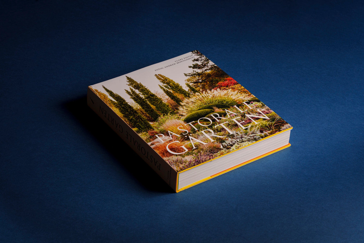 Bildband Pastorale Gärten – Cover mit Zypressen-Gartenmotiv schräg liegend, Buchrücken sichtbar